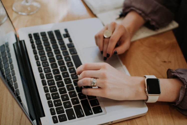 Picture of a woman typing on a laptop. Image is being used for blog post titled, Build Brand Awareness With Press Release Distribution