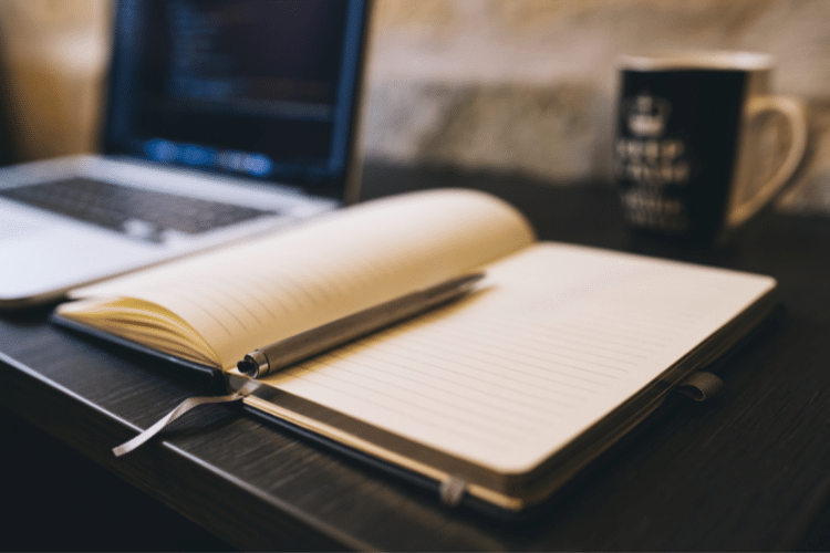 Image of an open laptop and open notebook. Image used for a blog post about building brand authority.