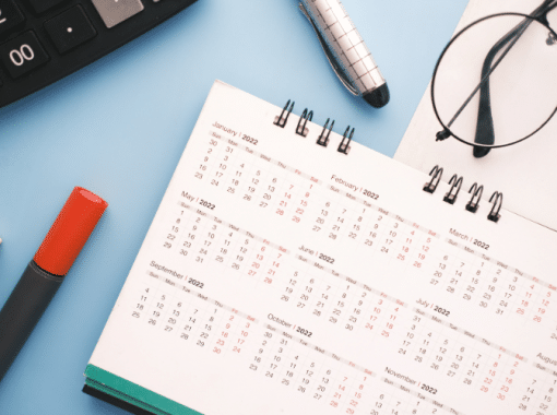 Picture of a calendar, pens, and keyboard for a blog post about holiday content creation.