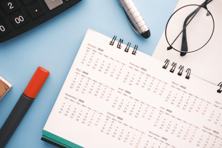 Picture of a calendar, pens, and keyboard for a blog post about holiday content creation.