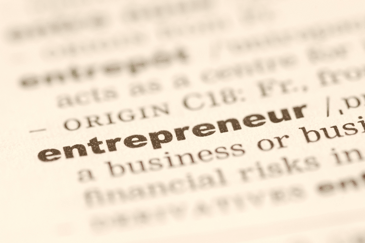 Picture of a dictionary with the word "entrepreneur" in bold font. Image is used for a Newswire blog about marketing tips for entrepreneurs.