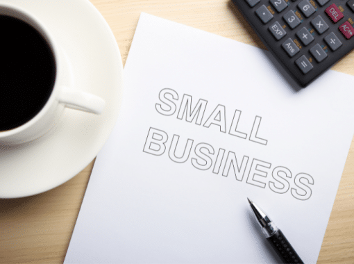 Picture of a white coffee cup filled with black coffee and a white sheet of paper that reads "small business." Image is used for a blog post about Small Business Saturday.