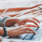 Picture of a woman typing on a laptop. Image is being used for a Newswire blog post about press release content.