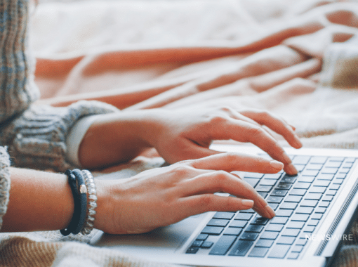 Picture of a woman typing on a laptop. Image is being used for a Newswire blog post about press release content.
