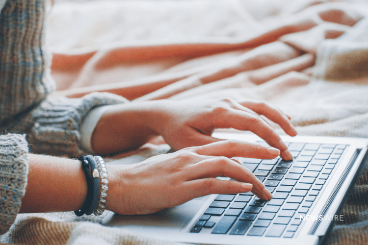 Picture of a woman typing on a laptop. Image is being used for a Newswire blog post about press release content.
