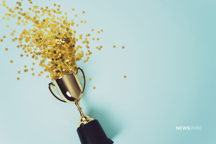 Picture of a trophy with gold confetti coming out of it on a blue background. Newswire branded image.