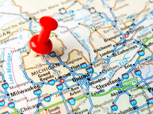 Close-up image of the state of Michigan on the map. A red thumbtack is placed on the state of Michigan. Image is being used for a Newswire blog post about the top media outlets in Michigan.