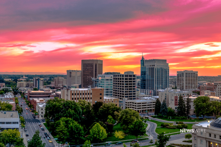Picture of downtown Boise with a beautiful pink, yellow, and orange sky. This image is being used for a Newswire blog post about the top media outlets in Idaho.